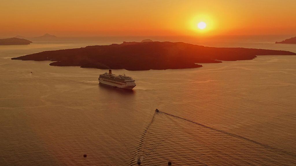 greece-santorini-architecture-island-161342-161342 A breathtaking sunset view of a cruise ship near the island of Santorini, Greece.