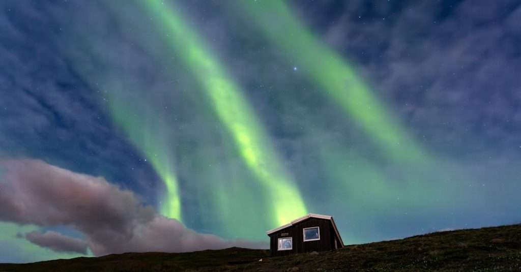 Beautiful aurora borealis above a cabin in Akureyri, Iceland at night.